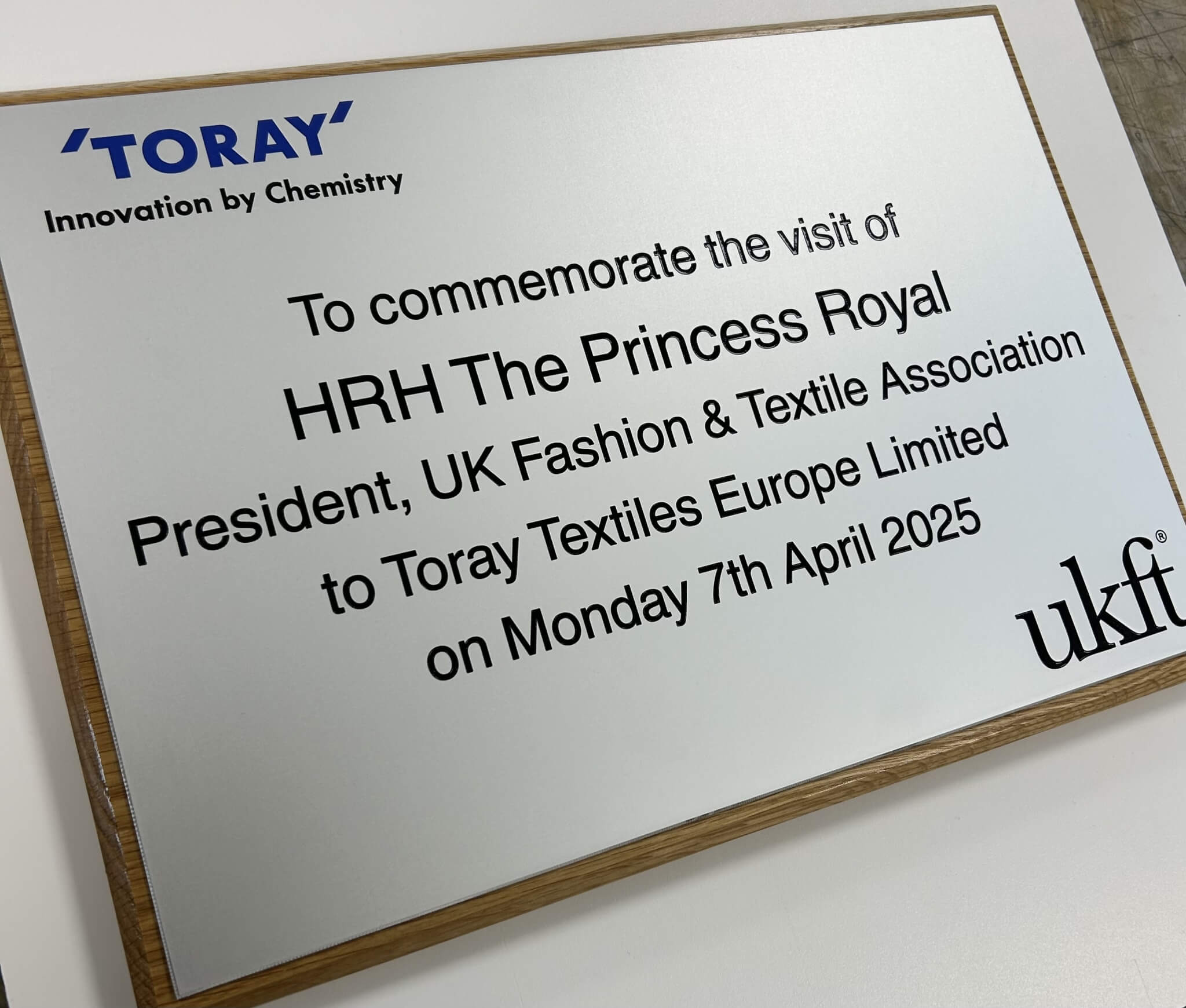 A silver plaque commemmorating the visit of an unnammed princss to Toray Textiles.