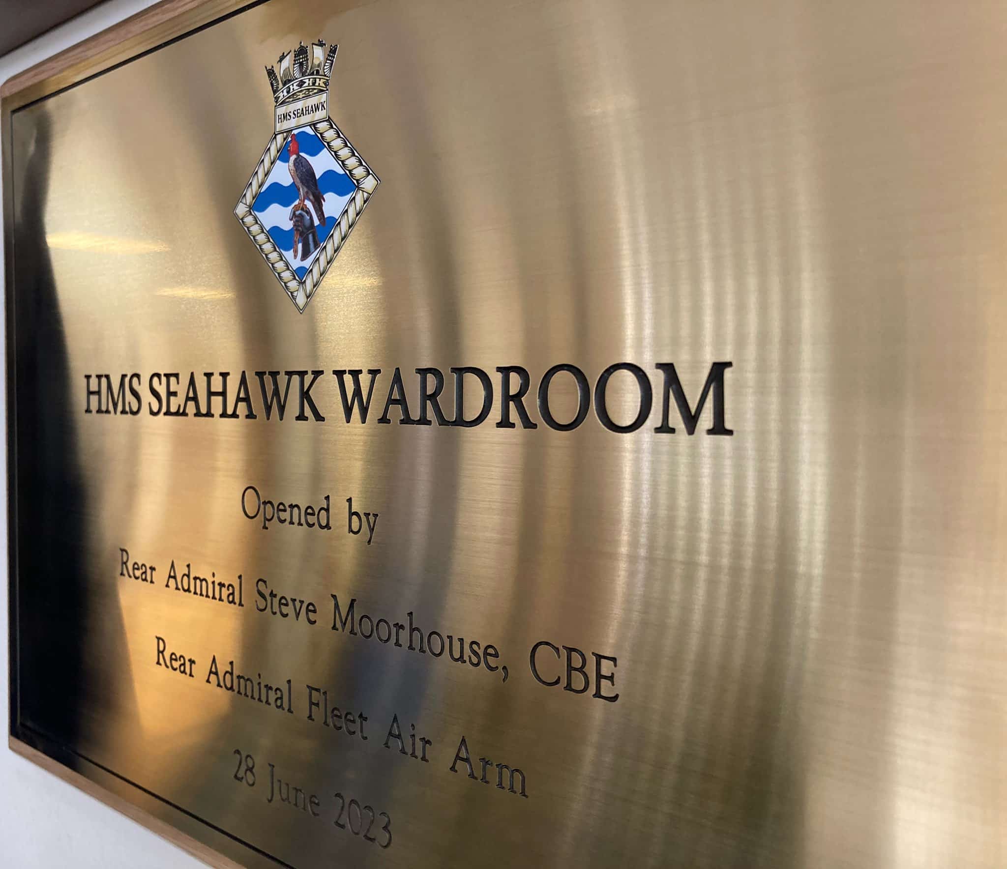 An angled closeup of the brass plaque labeled "HMS Seahawk Wardroom."
